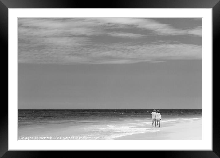 Retired couple walking barefoot by turquoise ocean Bahamas Framed Mounted Print by Spotmatik 