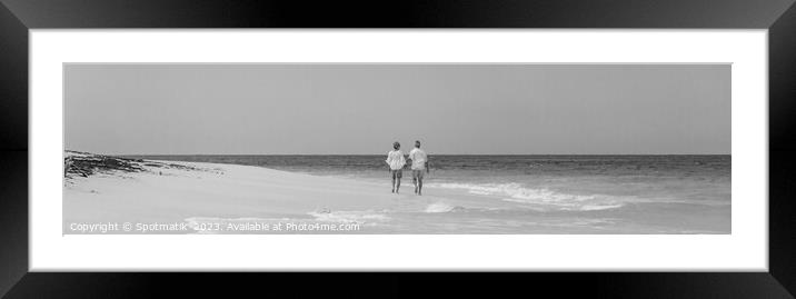 Panoramic view mature couple walking on beach Bahamas Framed Mounted Print by Spotmatik 