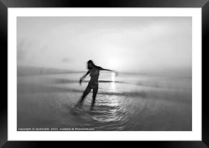 Motion blurred Asian girl dancing in ocean sunset Framed Mounted Print by Spotmatik 