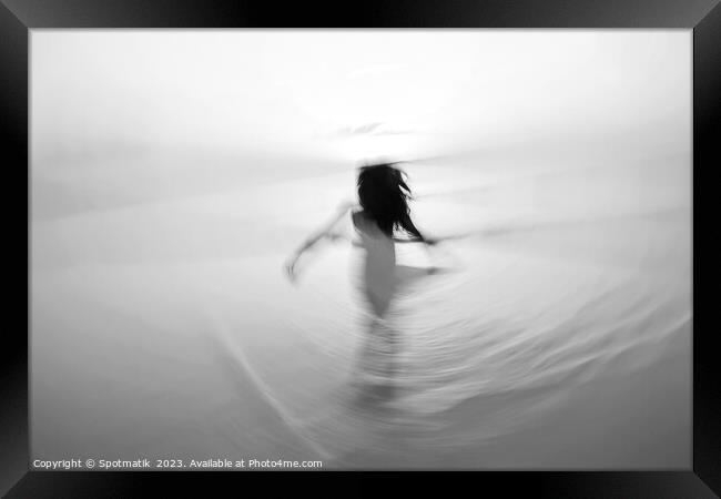 Motion blurred Asian girl dancing in ocean sunrise Framed Print by Spotmatik 