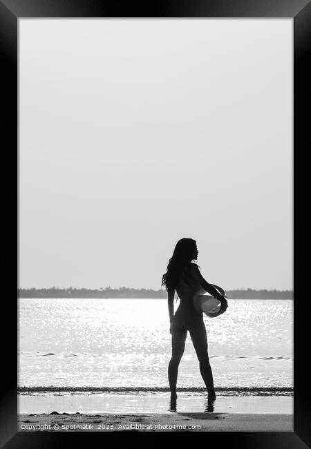 Tropical ocean sunrise with girl holding beach ball Framed Print by Spotmatik 