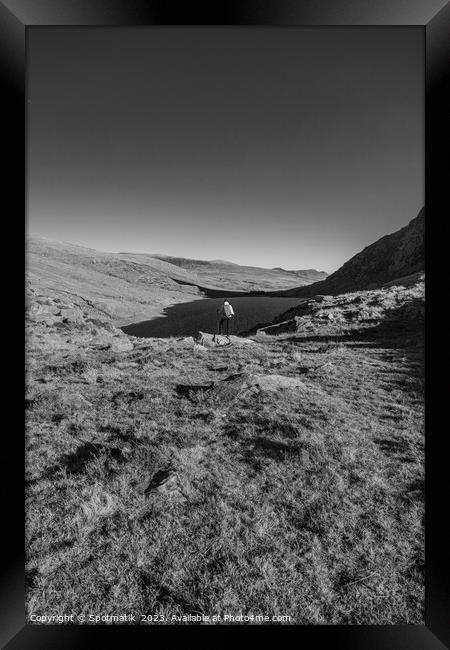 Lake in rural landscape with female backpacker Snowdonia Framed Print by Spotmatik 