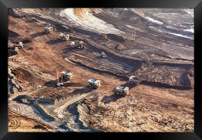 Aerial view giant dump trucks carrying mined Oilsand  Framed Print by Spotmatik 
