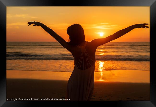 Carefree Bohemian girl dancing on beach at sunset Framed Print by Spotmatik 