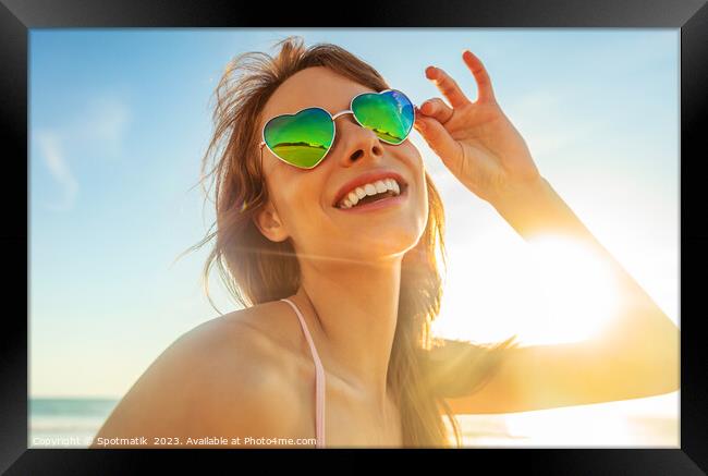 Caucasian girl wearing heart shaped sunglasses on beach Framed Print by Spotmatik 