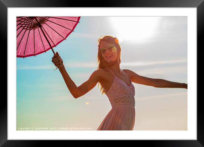 Young American female dancing on beach with parasol Framed Mounted Print by Spotmatik 