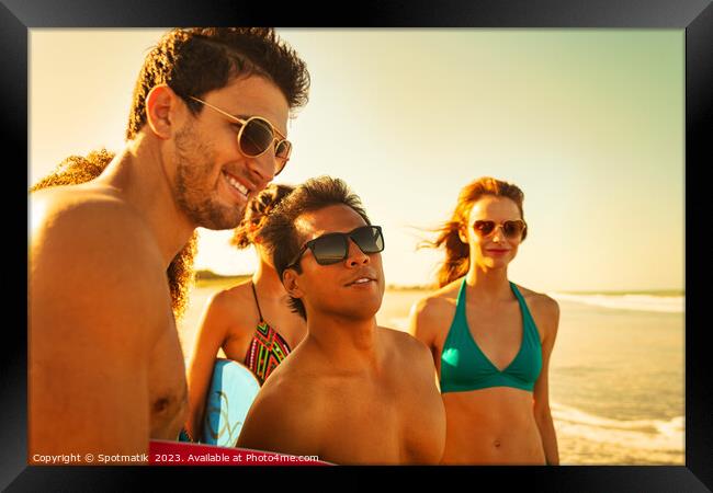 Friends on beach going bodyboarding on Summer vacation Framed Print by Spotmatik 
