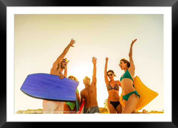 Friends in swimwear with bodyboards celebrating Summer vacation Framed Mounted Print by Spotmatik 