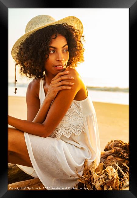 Solo African American woman sitting on beach driftwood Framed Print by Spotmatik 