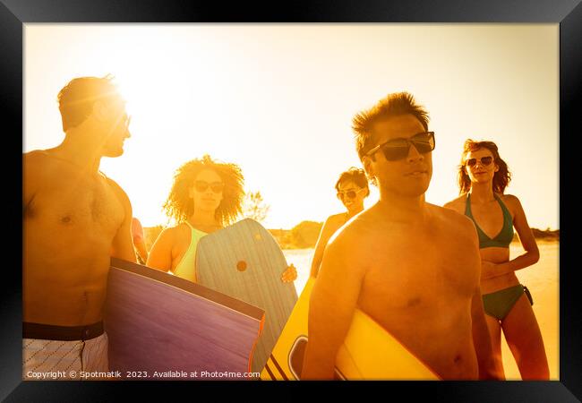 Friends in swimwear carrying bodyboards enjoying Summer vacation Framed Print by Spotmatik 
