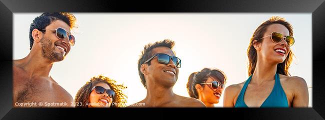 Panoramic view of smiling young friends in sunglasses Framed Print by Spotmatik 