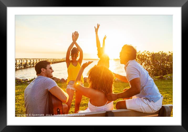 Friends dancing to guitar music outdoors at sunset Framed Mounted Print by Spotmatik 