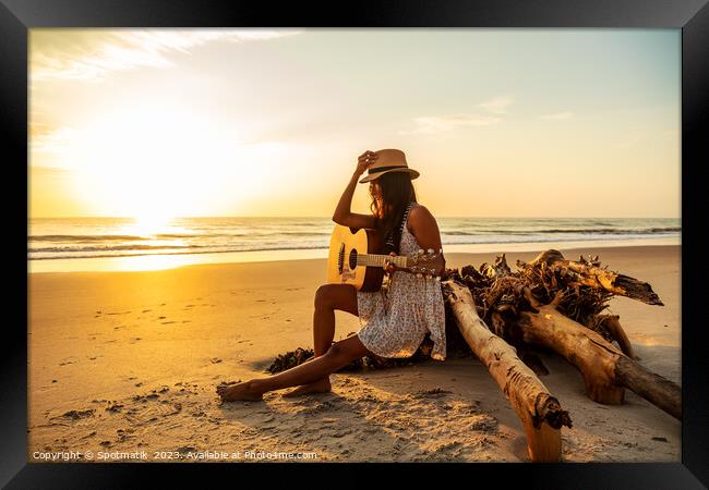 Indian female sitting on driftwood with ocean sunrise Framed Print by Spotmatik 