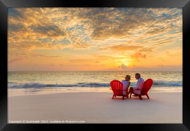Mature couple enjoying ocean sunset on beach Bahamas Framed Print by Spotmatik 