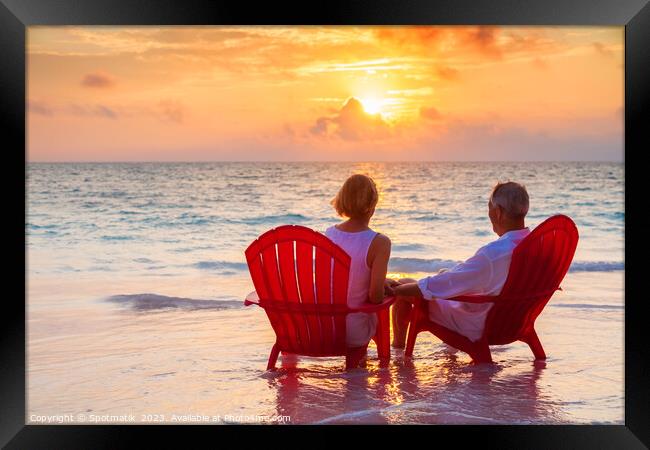 Retired couple enjoying sunset view over ocean Bahamas Framed Print by Spotmatik 