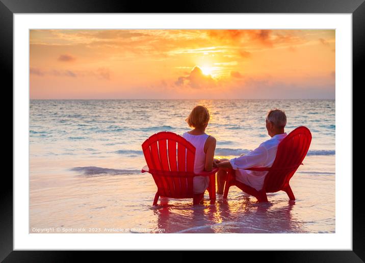 Retired couple enjoying sunset view over ocean Bahamas Framed Mounted Print by Spotmatik 