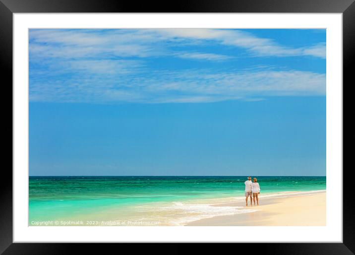 Retired couple walking barefoot by turquoise ocean Bahamas Framed Mounted Print by Spotmatik 