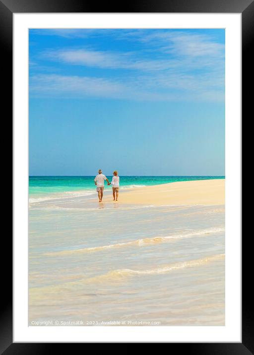 Mature couple walking on beach by ocean Bahamas Framed Mounted Print by Spotmatik 