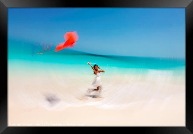 Motion blurred young woman flying kite on beach Framed Print by Spotmatik 