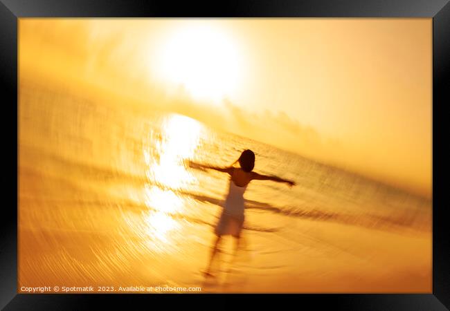 Motion blur Asian woman walking in ocean waves Framed Print by Spotmatik 