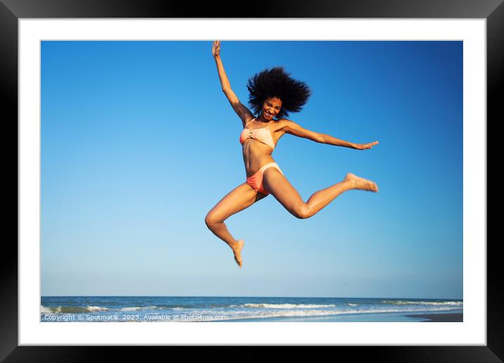 Fun loving Afro female jumping by the ocean Framed Mounted Print by Spotmatik 