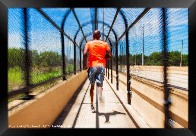 Solo African American man running through covered walkway Framed Print by Spotmatik 