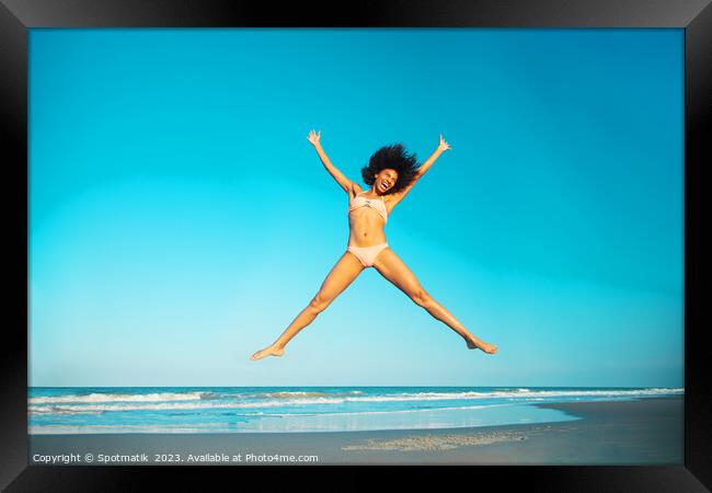 Healthy African American girl jumping high on beach Framed Print by Spotmatik 