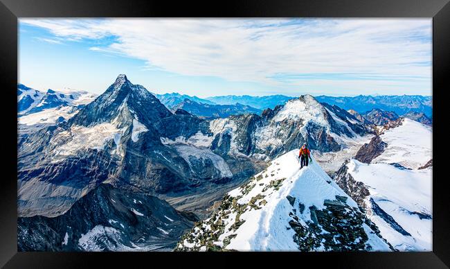 Alpinist on Dent Blanche with Matterhorn in the background Framed Print by Julian Carnell