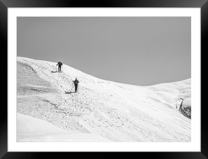 Two Hikers on a trail walking through snow. Winter landscape in Carapathian Mountains, Romania. Framed Mounted Print by Cristi Croitoru