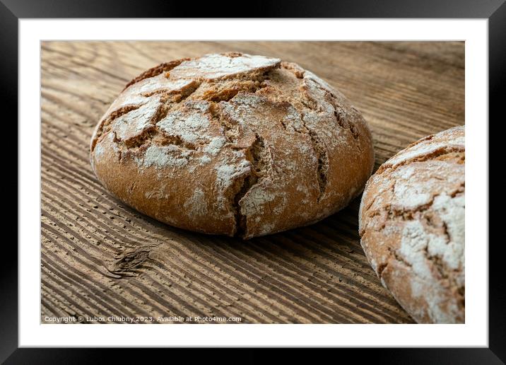 Delicious baked bread on a wooden background Framed Mounted Print by Lubos Chlubny