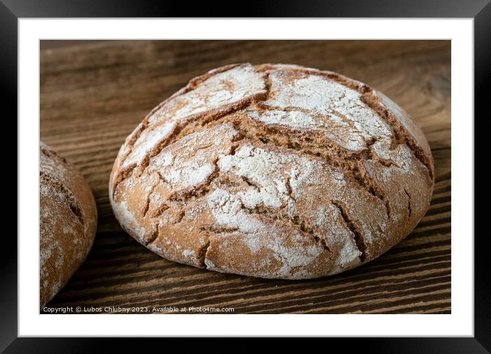 Delicious baked bread on a wooden background Framed Mounted Print by Lubos Chlubny