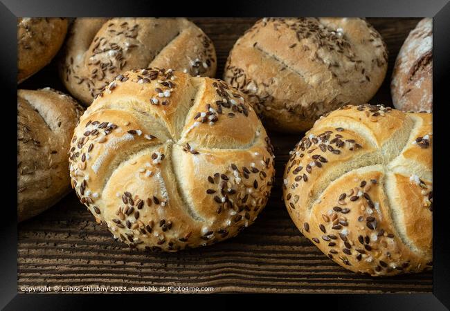 Different bread on a rustic wooden background. Bakery assortment of bread. Framed Print by Lubos Chlubny