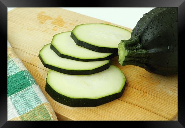 Close up of sliced zucchini on wooden cutting board Framed Print by Irena Chlubna