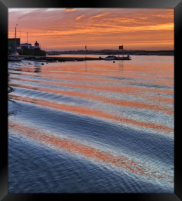 Sunrise reflections over er the passing wakes at Brightlingsea Harbour Framed Print by Tony lopez