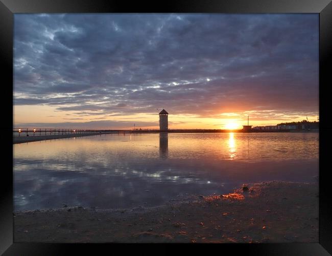 Sun setting over Batemans Tower in Brightlingsea in full reflections  Framed Print by Tony lopez