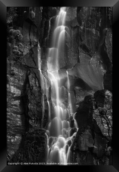 A waterfall cascading down black rock cliff Framed Print by Alex Fukuda