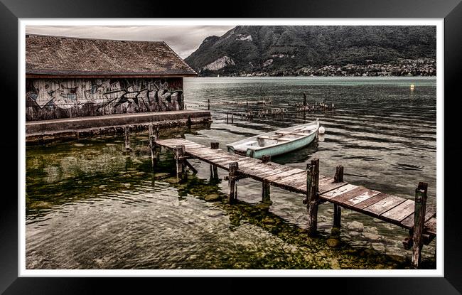 Wooden boat by boathouse with graffiti  Framed Print by Lesley Carruthers