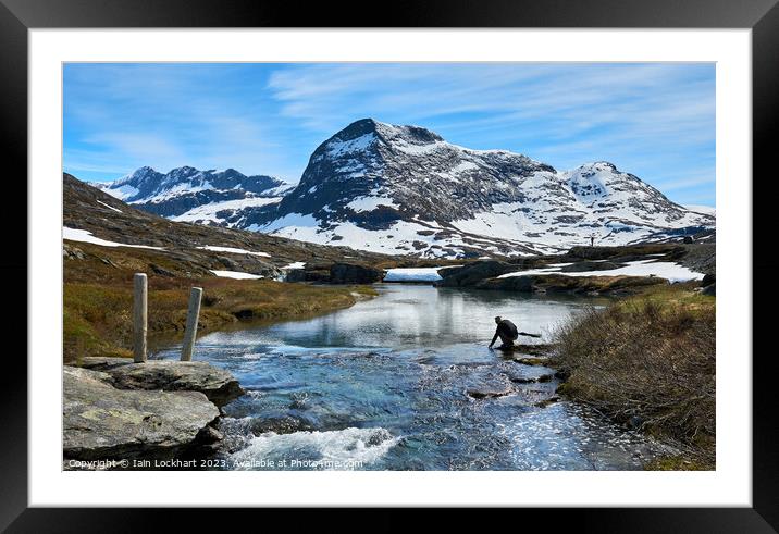 Refilling water bottle from mountain stream Framed Mounted Print by Iain Lockhart