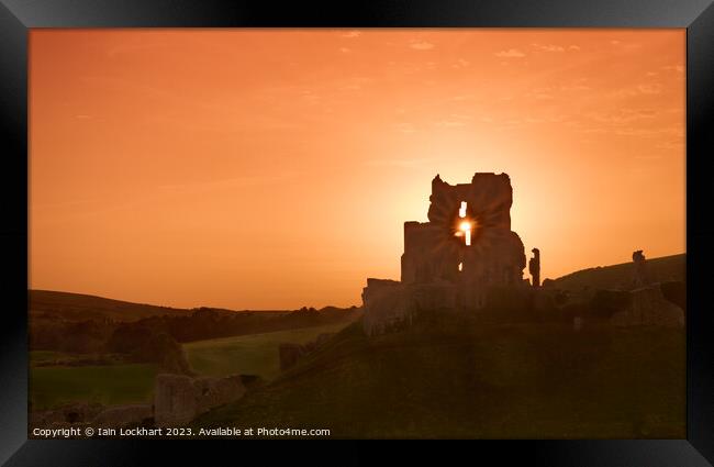 Corfe Castle silhouetted against the sunset Framed Print by Iain Lockhart