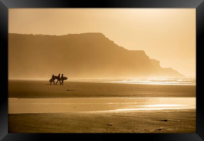 Surfers at sunset Framed Print by Robert Canis