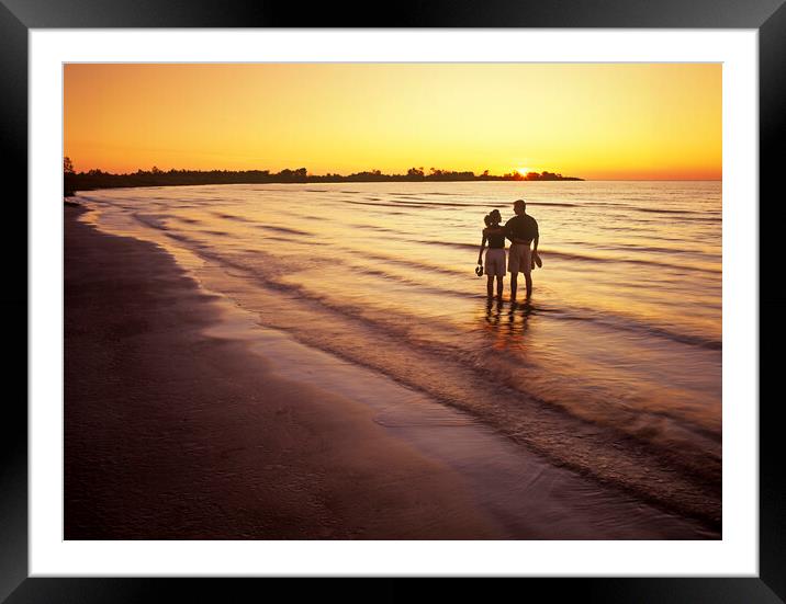 couple along beach at sunset Framed Mounted Print by Dave Reede