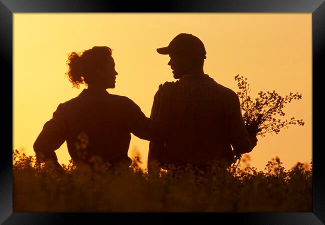 couple in bloom stage canola field Framed Print by Dave Reede