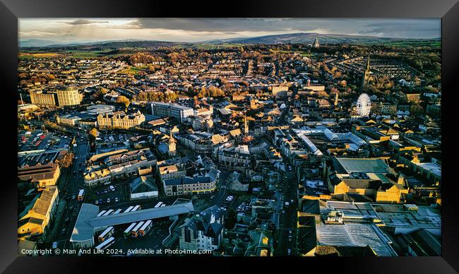 Aerial view of a city Lancaster at sunset with warm lighting highlighting the buildings and streets, showcasing the urban landscape. Framed Print by Man And Life