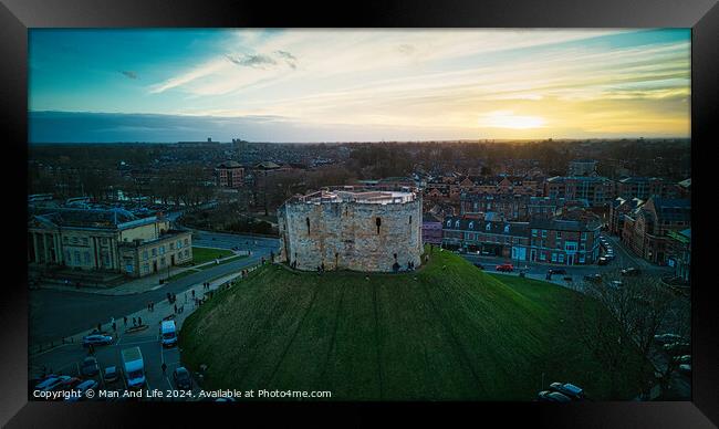 Aerial view of a historic castle at sunset with surrounding cityscape and dramatic sky in York, North Yorkshire Framed Print by Man And Life