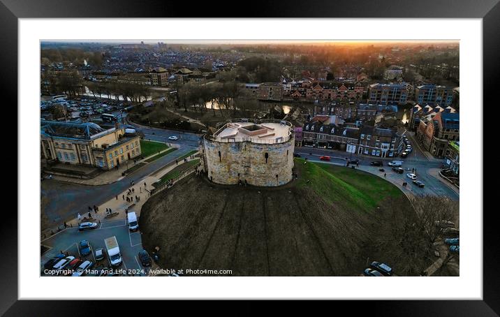 Aerial view of a historic circular stone fortress at dusk, with surrounding urban landscape and sunset sky in York, North Yorkshire Framed Mounted Print by Man And Life