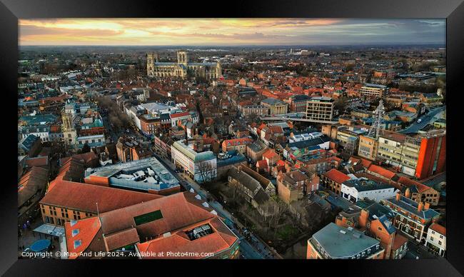 Aerial view of a European city at sunset with warm lighting, showcasing historic buildings and urban landscape in York, North Yorkshire Framed Print by Man And Life