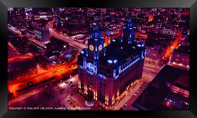Aerial night view of an illuminated historic building amidst city streets with vibrant red traffic trails in Liverpool, UK. Framed Print by Man And Life