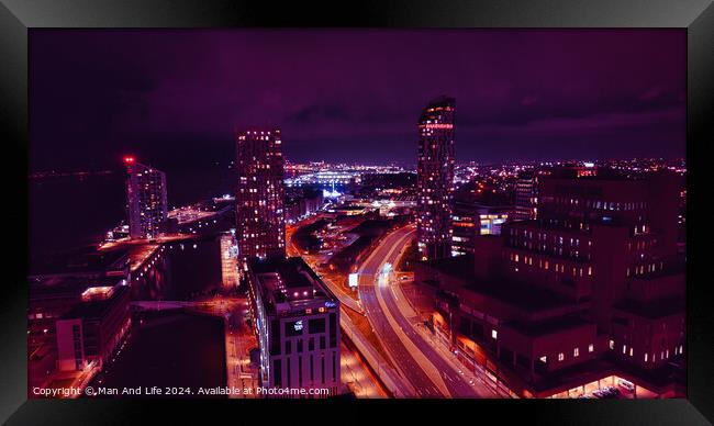 Night cityscape with illuminated buildings and streets, showcasing urban architecture and traffic trails under a purple sky in Liverpool, UK. Framed Print by Man And Life