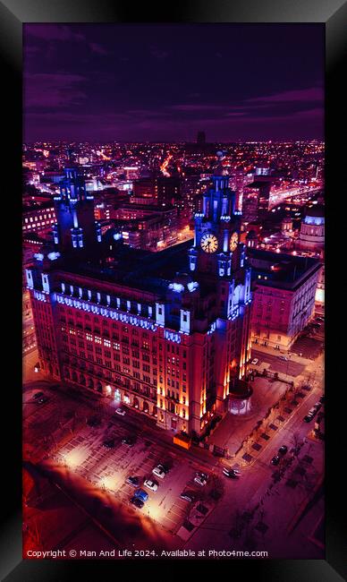 Aerial night view of an illuminated historic building in an urban cityscape with vibrant purple skies in Liverpool, UK. Framed Print by Man And Life