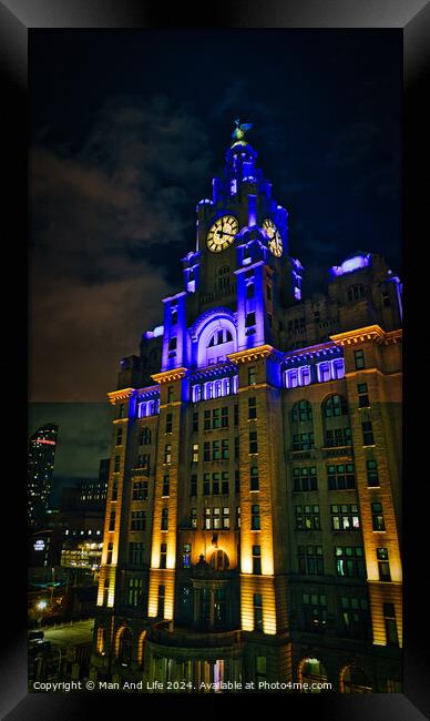 Liverpool's iconic Royal Liver Building at night, illuminated with blue lights against a dark sky. Framed Print by Man And Life
